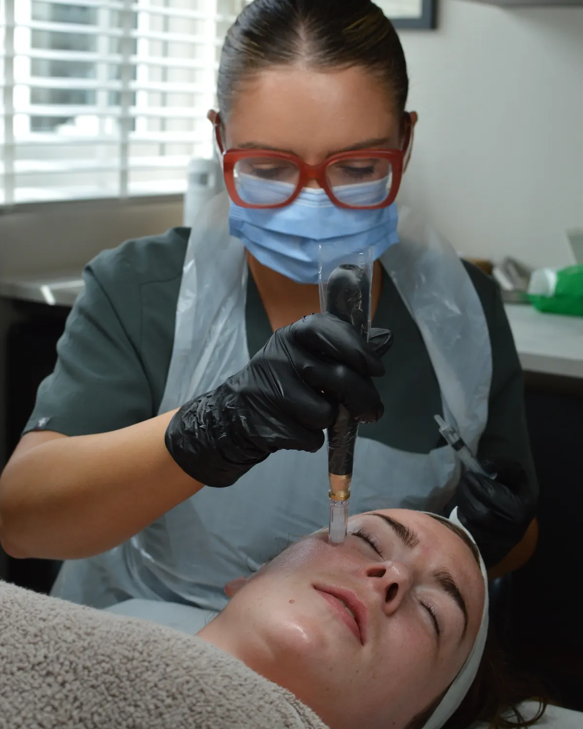 Tammy microneedling a client with a professional pen